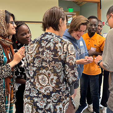 grad students standing in a circle smiling and laughing